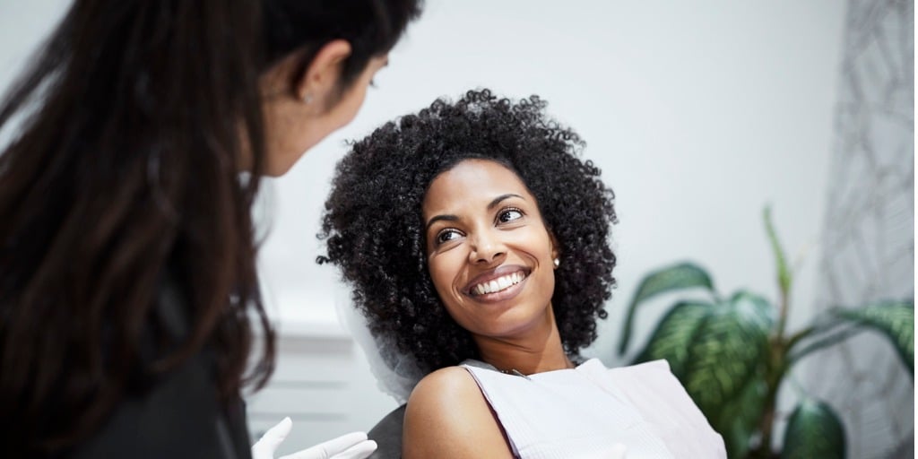 dentist discussing with smiling female patient picture